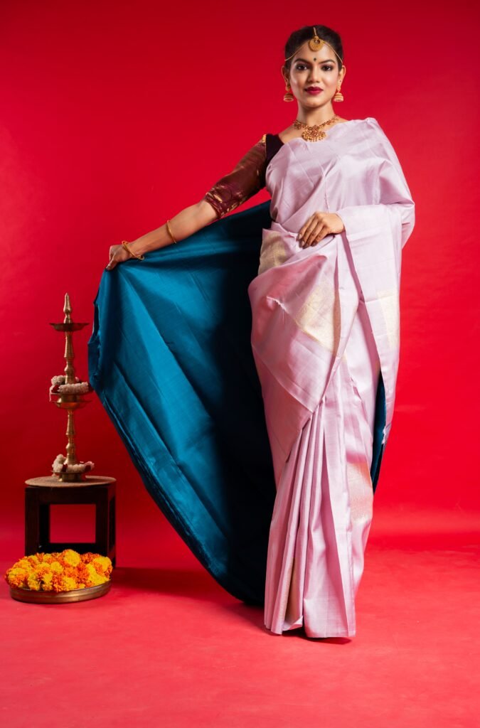 A woman poses gracefully in a Shrivvi Sarees silk drape during a festive-themed photoshoot by Urbanpixelites.